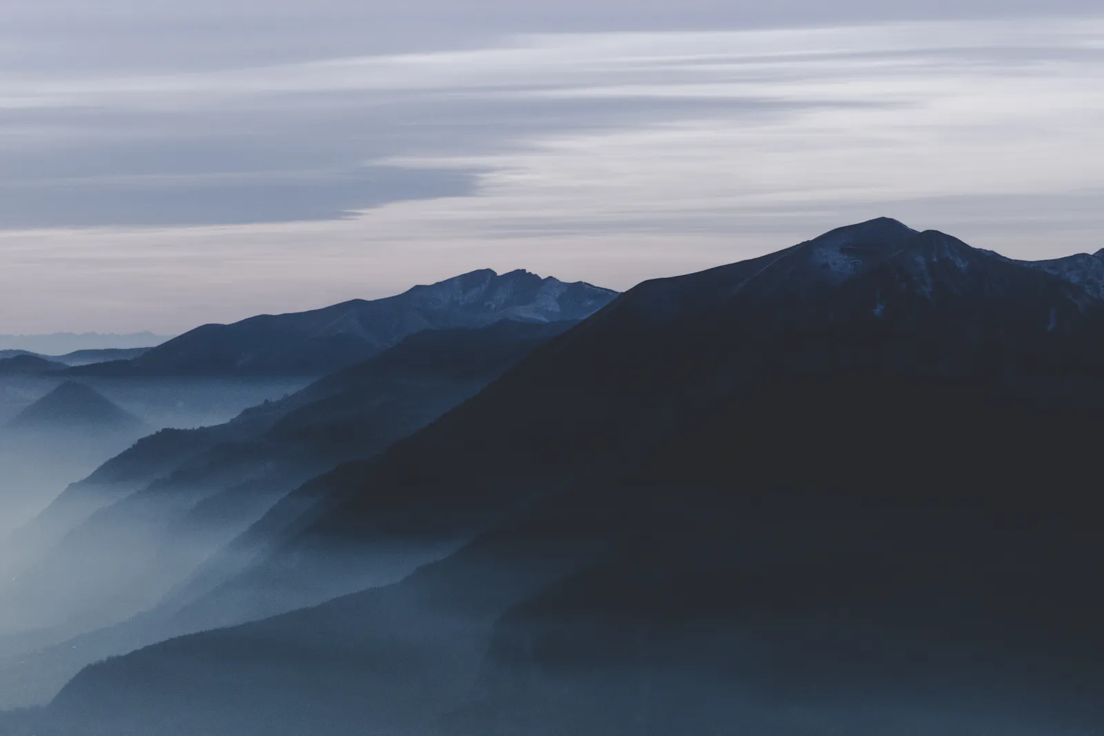 Dark mountain ridges rising above low cloud.