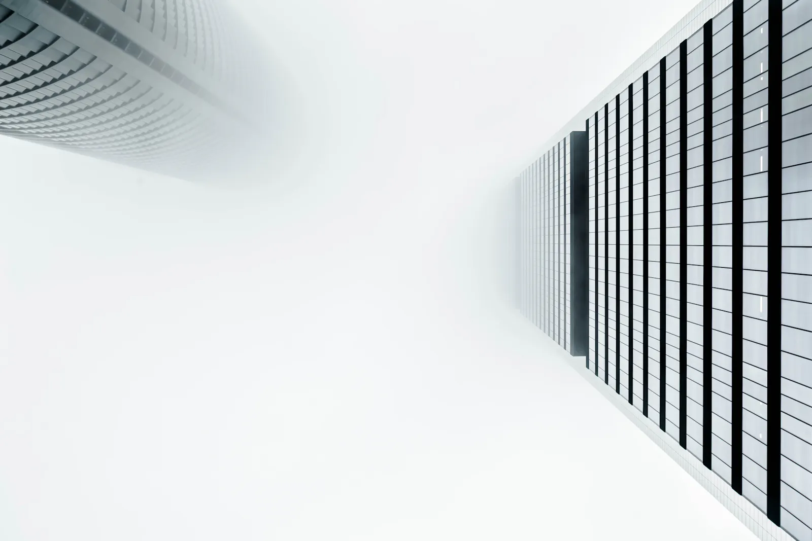 Two tall buildings framing an opening of pale sky.