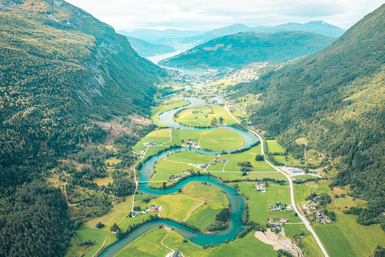 A winding river and roads crossing a broad valley.