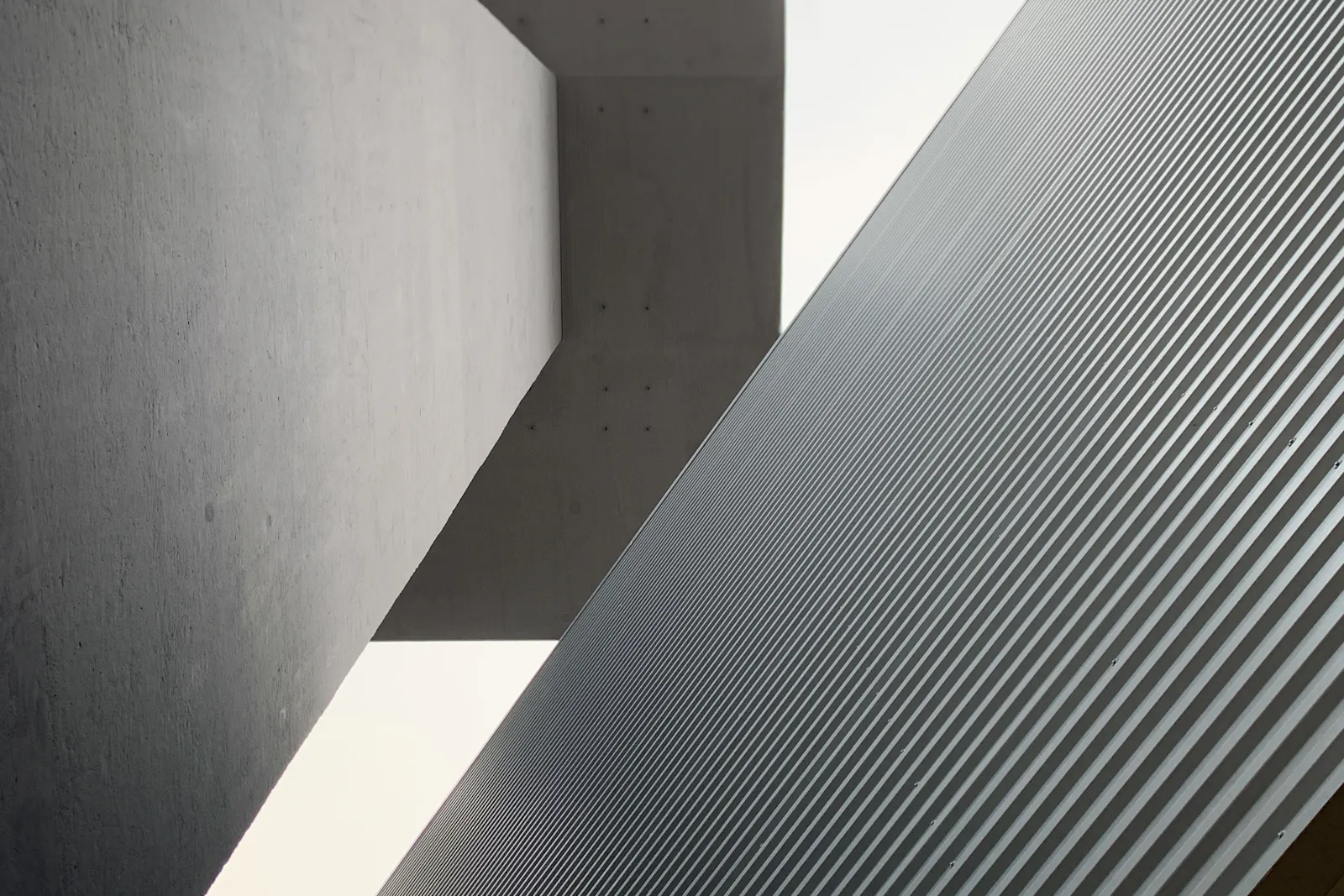 Sunlight cutting across a recessed concrete wall.