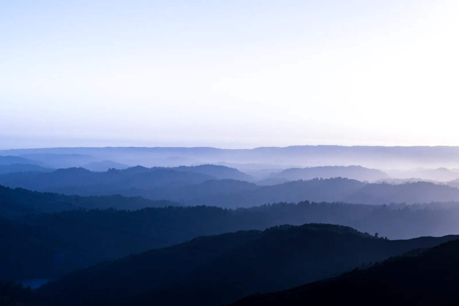 Mountain ridges receding into blue evening haze.