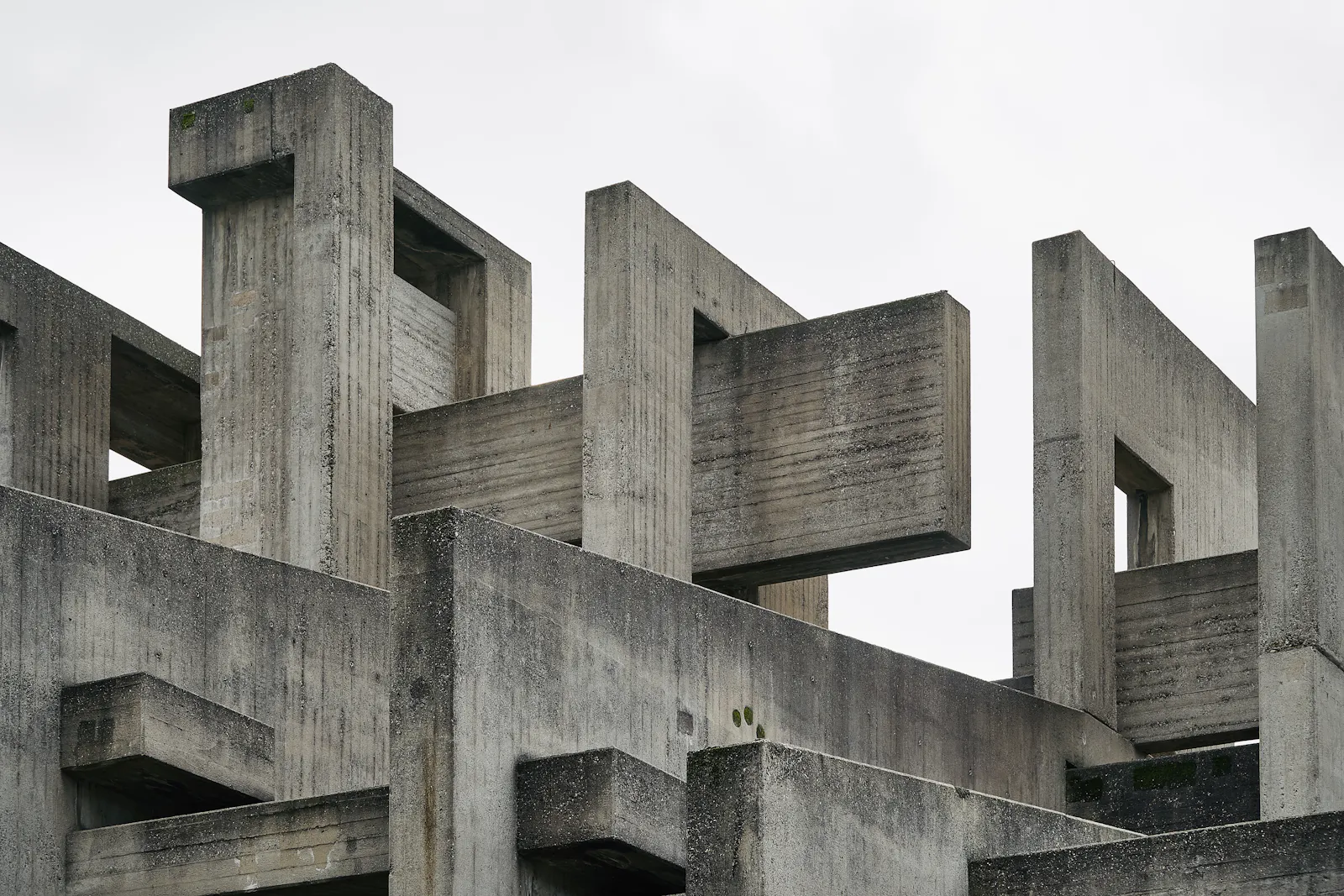 Interlocking concrete beams against a pale sky.